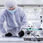 A factory worker works on the assembly line in a safety suit