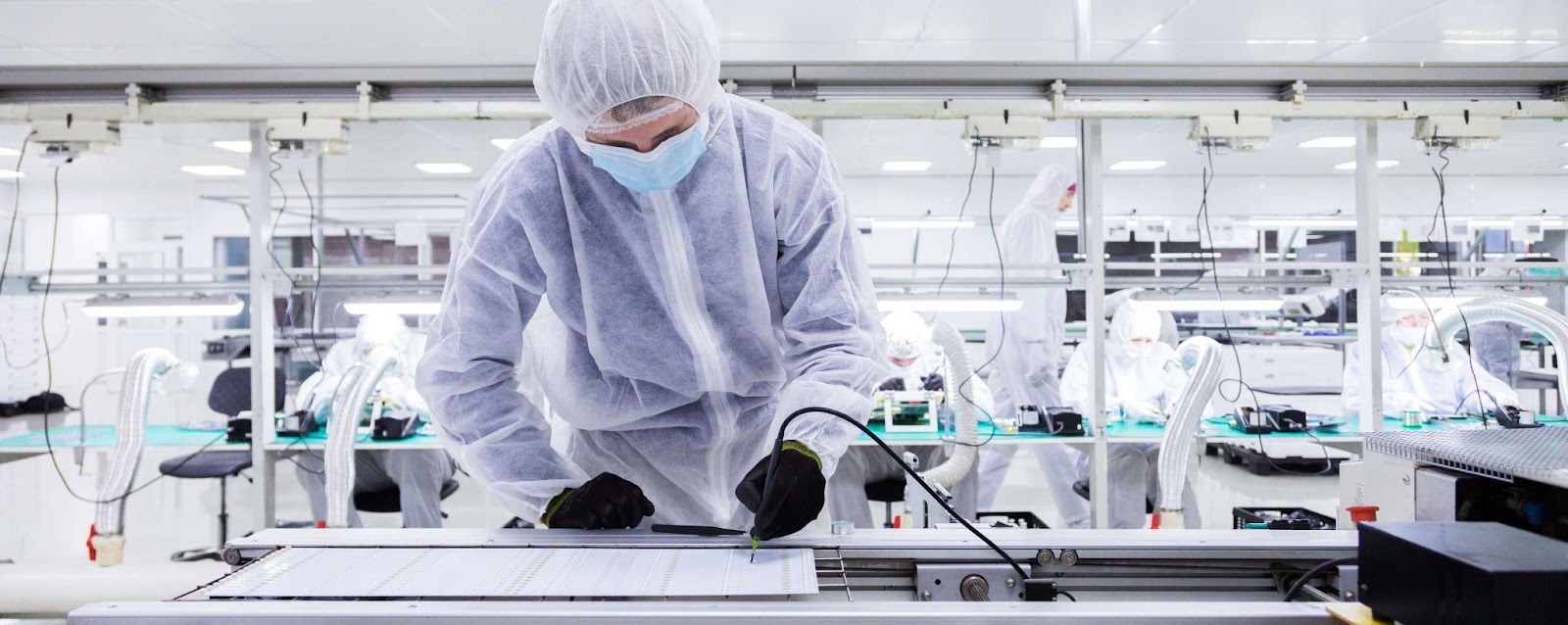 A factory worker works on the assembly line in a safety suit