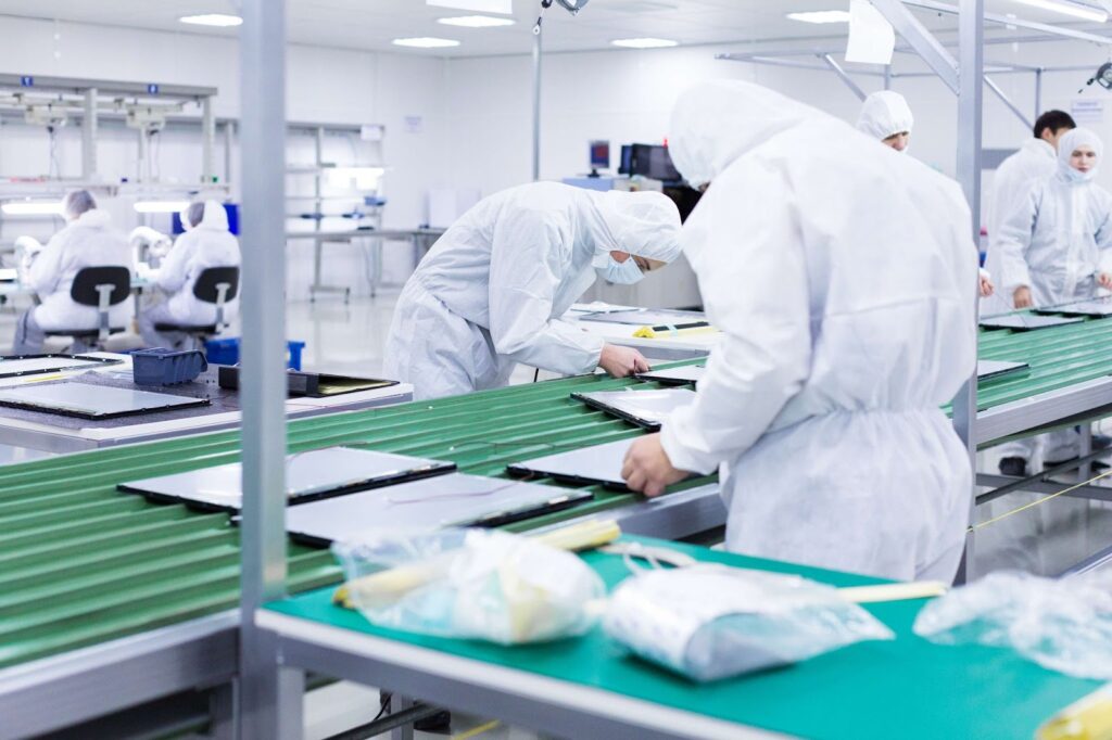 A group of factory workers work on a assembly line