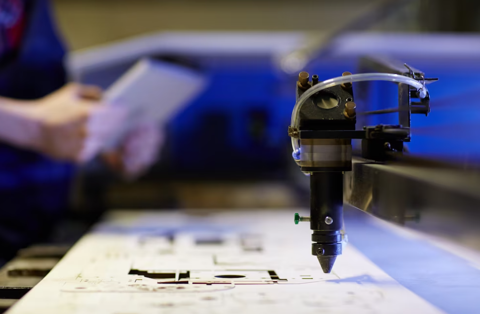 man holds a notebook on a blurred background and cnc machine