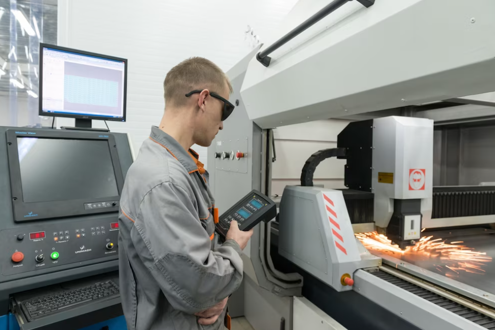 man in black glasses and a grey suit controls the machining process