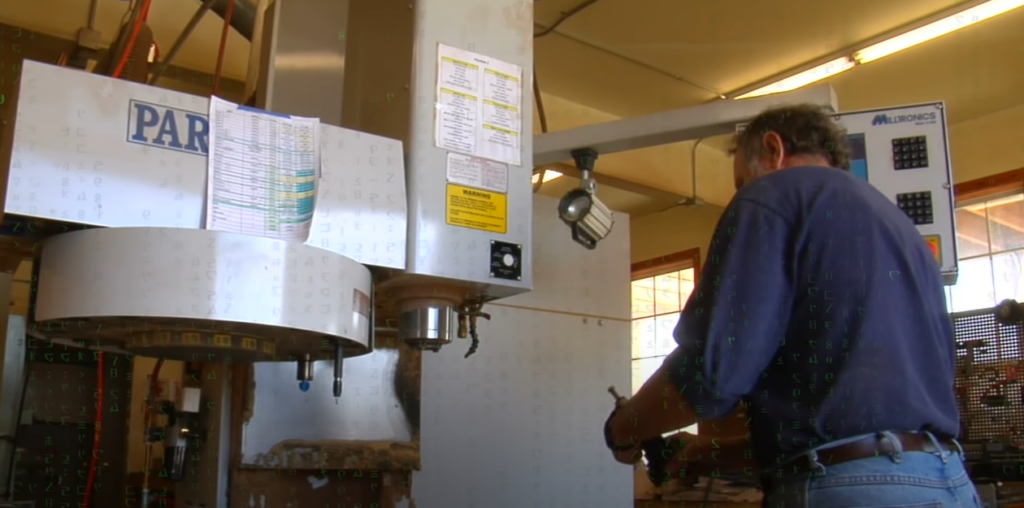 A man standing in front of a CNC mill