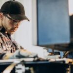 A man in safety glasses works at a machine